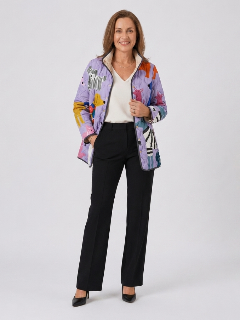 Woman wearing the Josephine quilted little dog jacket open over an ivory top with black trousers