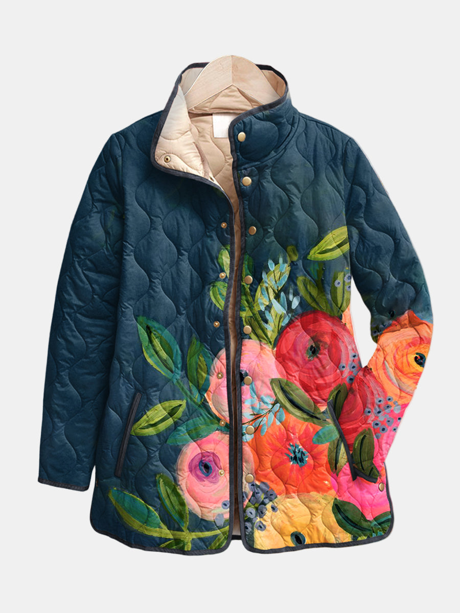 Evangeline quilted jacket shown flat: poppies and peonies placed on one side of a deep teal-blue ground, gold-tone snap front