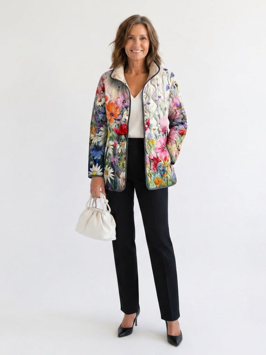 Woman wearing the Emmeline quilted wildflower jacket open over an ivory top with black trousers