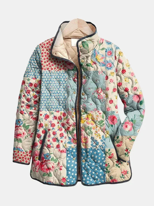 Genevieve quilted jacket shown flat: dusty blue, pink and cream patchwork squares, gold-tone snap front, stand collar with cream lining