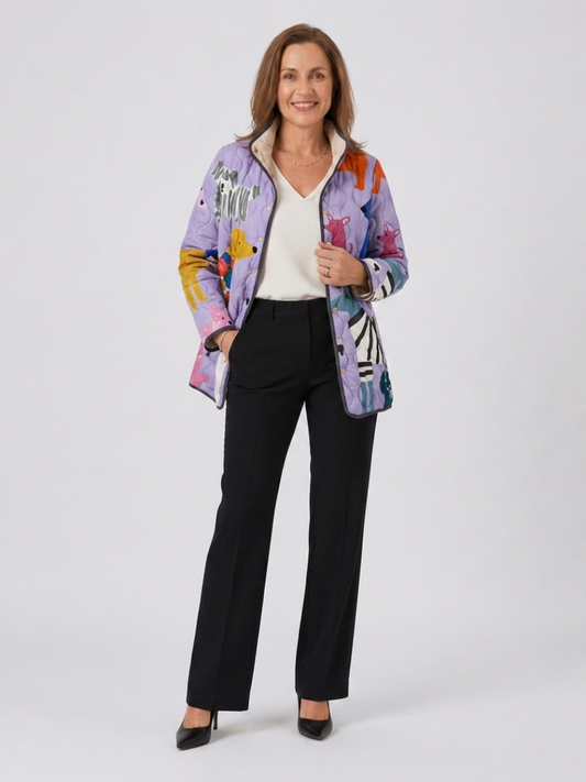Woman wearing the Josephine quilted little dog jacket open over an ivory top with black trousers