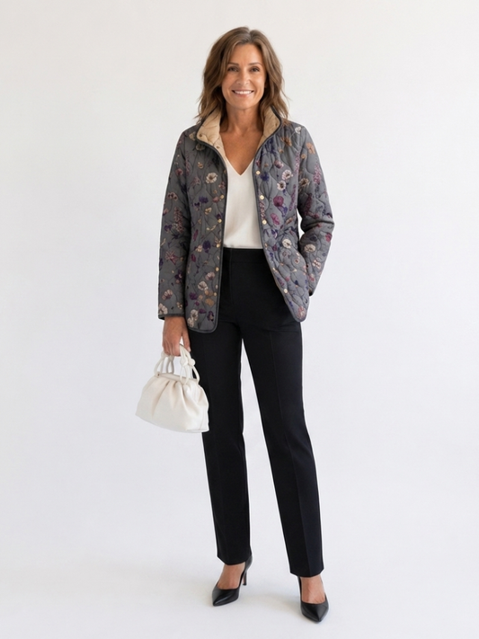 Woman wearing the Dorothea quilted dried flower jacket open over an ivory top with black trousers