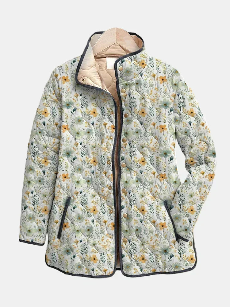 Annabel quilted jacket shown flat: tiny meadow flowers on cream with dark gray edging and a stand collar