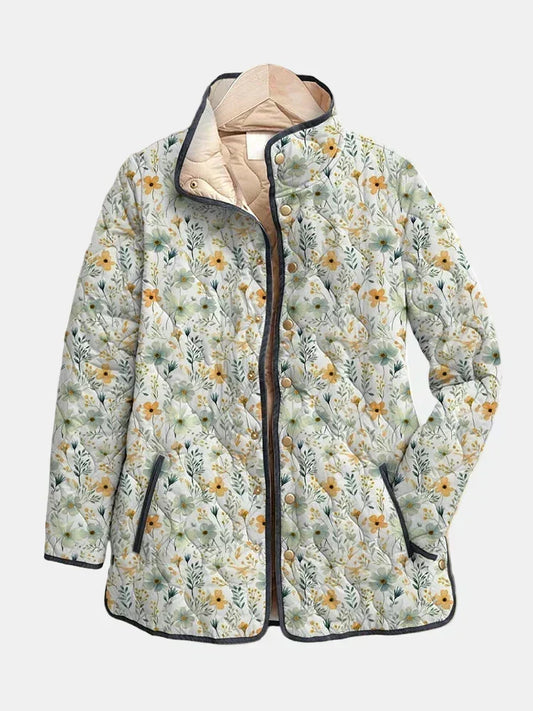 Annabel quilted jacket shown flat: tiny meadow flowers on cream with dark gray edging and a stand collar