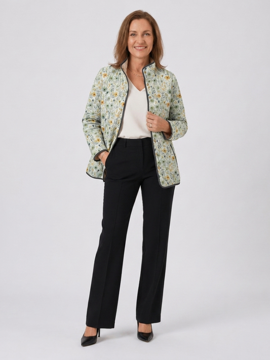 Woman wearing the Annabel quilted countryside floral jacket open over an ivory top with black trousers