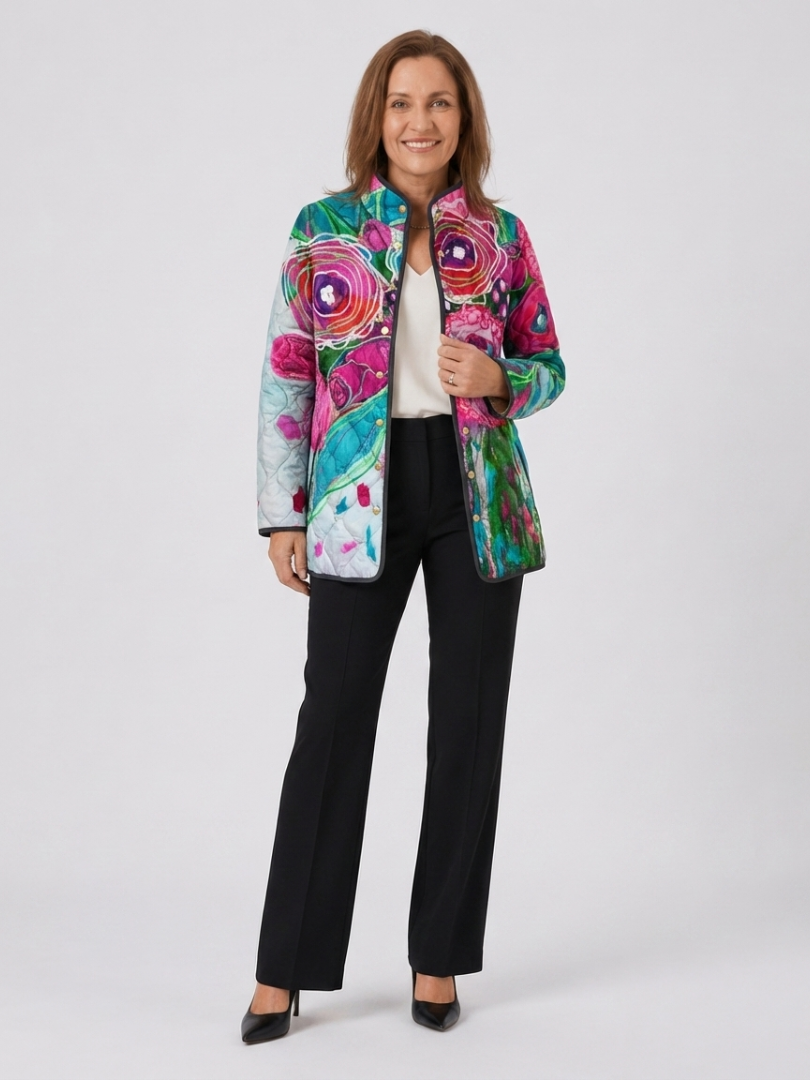 Woman wearing the Lavinia quilted floral watercolor jacket open over an ivory top with black trousers