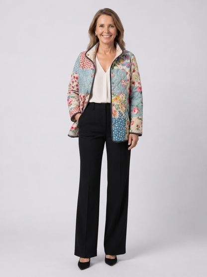 Woman wearing the Genevieve quilted floral patchwork jacket open over an ivory top with black trousers
