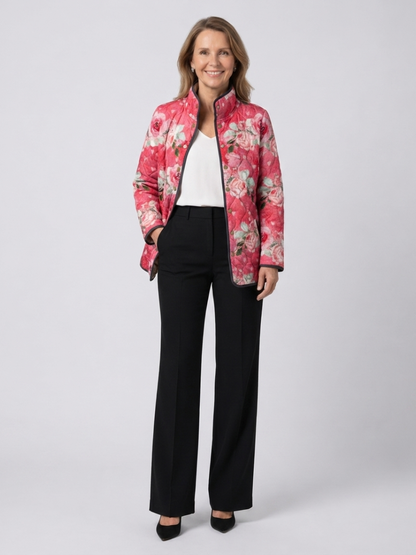 Woman wearing the Cordelia quilted dusty rose jacket open over an ivory top with black trousers