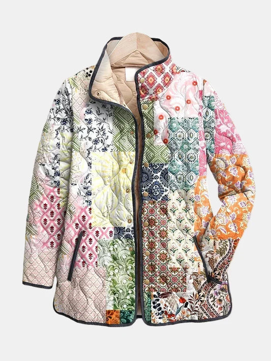 Isadora quilted jacket shown flat: paisley and floral patchwork on cream with dark navy piping and stand collar