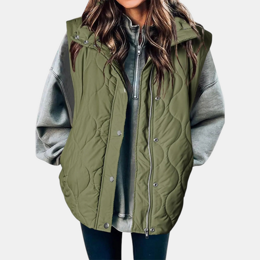 Juliette olive green quilted hooded puffer vest worn open over a gray hoodie