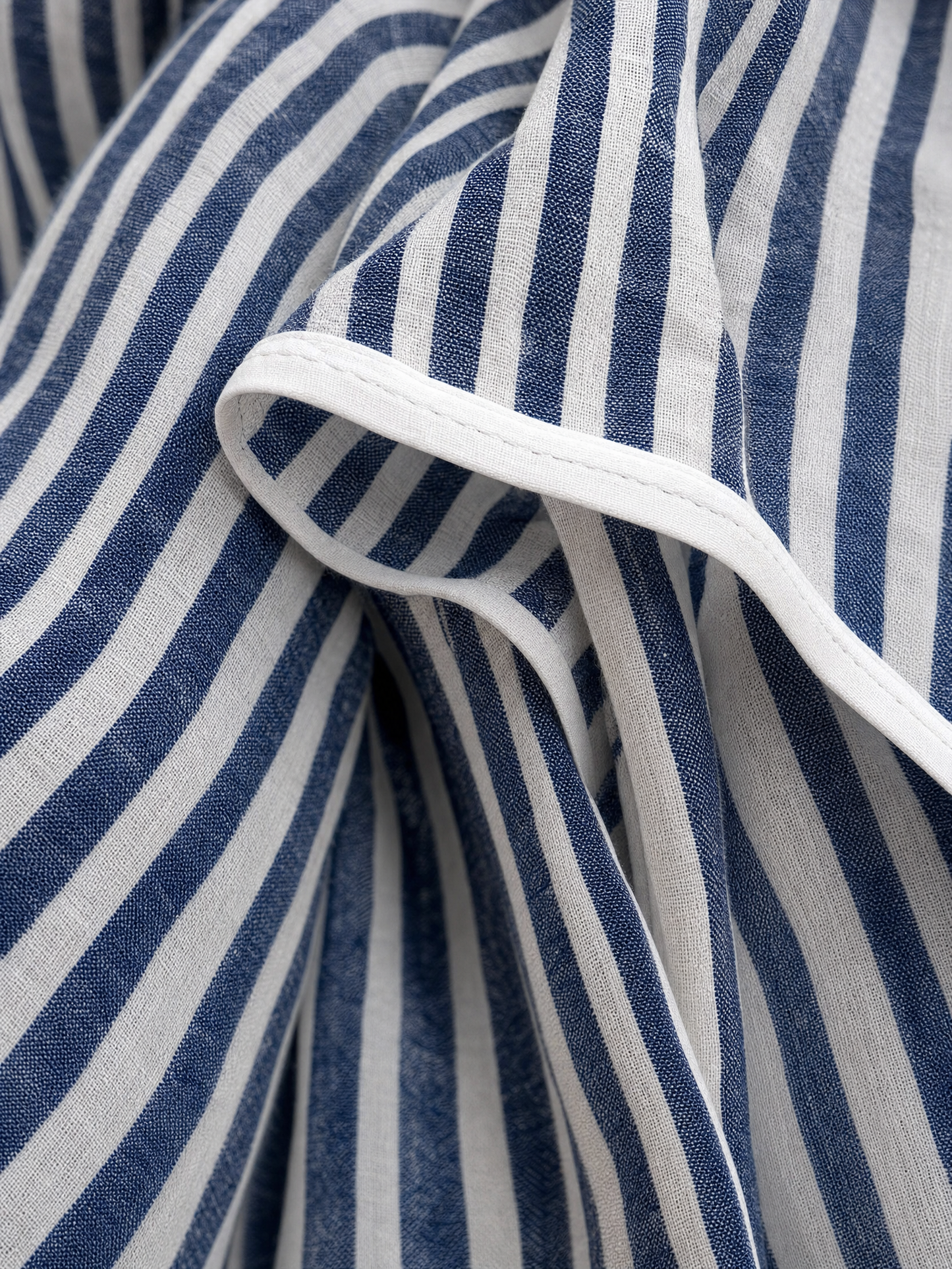 Close-up of the navy and white striped linen fabric with white piping
