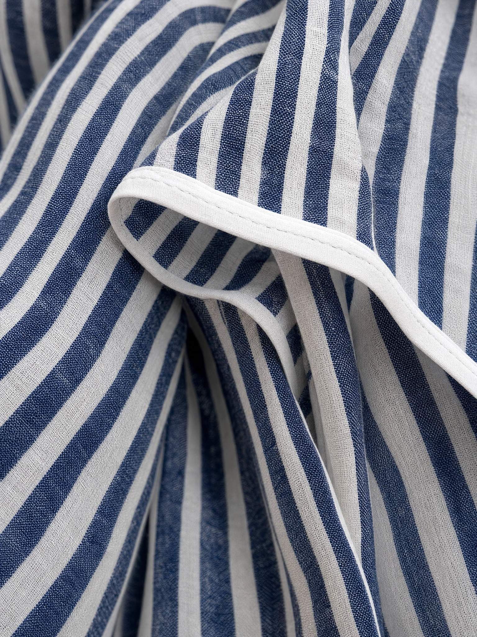 Close-up of the navy and white striped linen fabric with white piping