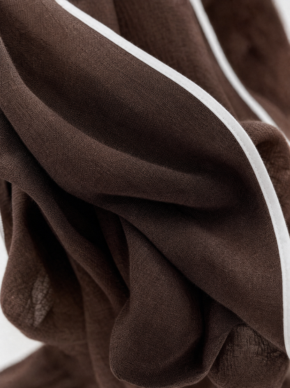 Close-up of the brown linen blend fabric with white piping