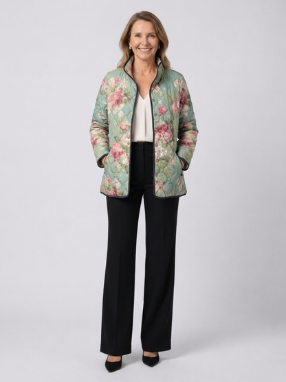 Woman wearing the Rosemary quilted vintage rose jacket open over an ivory top with black trousers